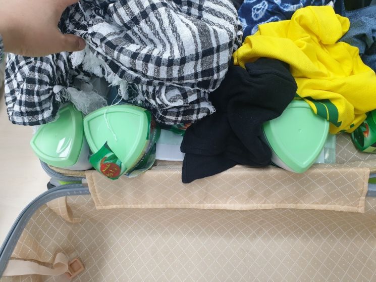 대마초를 숨겨 놓은 헤어크림 용기가 여행자 가방 속 옷가지에 덮여 있다. 관세청 제공