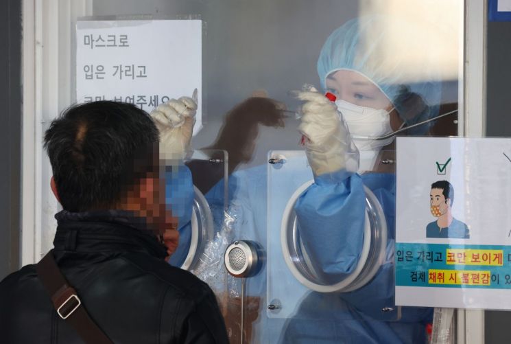 지난 26일 오전 서울역광장에 마련된 코로나19 임시선별검사소를 찾은 시민이 검체 검사를 받고 있다. ＜사진=연합뉴스＞