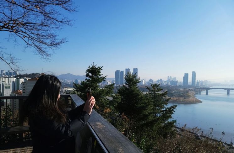 성동구 명소 달맞이 공원에서 풍경을 영상에 담고 있는 구민