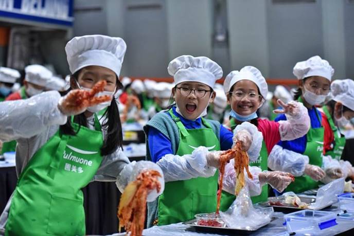 10월 21일 북경한국학교 대강당에서 초등학교 전 학년을 대상으로 진행된 김치 담그기 행사에서 학생들이 직접 만든 김치를 들고 활짝 웃고 있다.