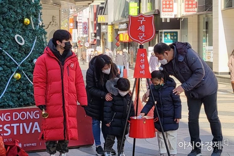 1일 오후 12시쯤 서울 중구 명동을 찾은 한 가족이 구세군 자선냄비에 성금을 기부하고 있다./박현주 기자 phj0325@