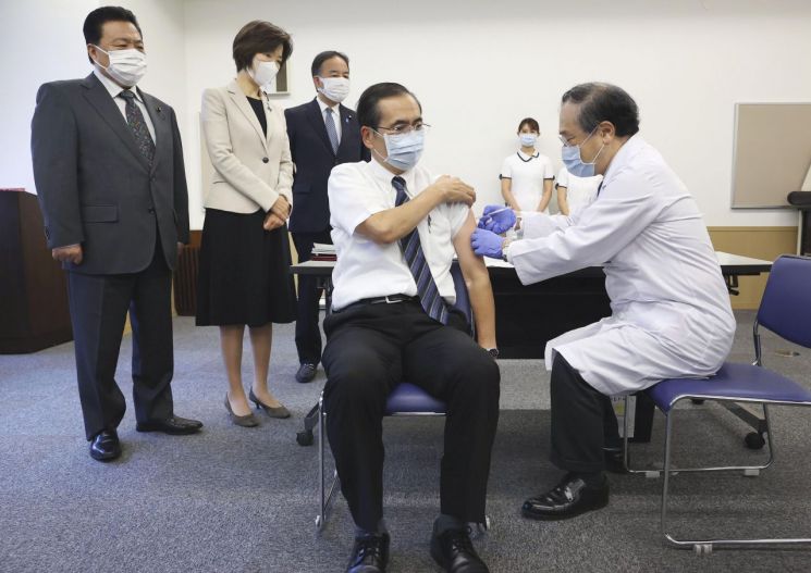 아라키 가즈히로 일본 도쿄의료원 원장(가운데)이 1일 도쿄에서 호리우치 노리코 백신 담당상(왼쪽 두 번째)이 지켜보는 가운데 코로나19 백신 3차 접종(부스터샷)을 받고 있다. 일본은 이날 코로나19 백신 3차 접종을 개시했다. 3차 접종 대상은 원칙적으로 2회 접종이 끝나고 8개월이 지난 18세 이상 일본 거주자이며, 우선 약 200만 명의 의료종사자를 대상으로 이뤄진다. ＜사진=AP교도연합＞