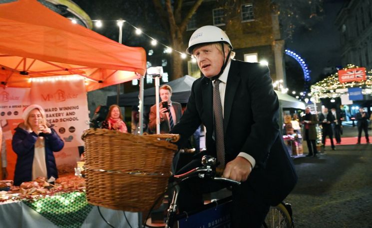 보리스 존슨 영국 총리가 지난달 30일(현지시간) 런던 다우닝가 10번지 총리 관저 인근의 크리스마스 시장에서 자전거를 타고 있다. ＜사진=EPA연합＞