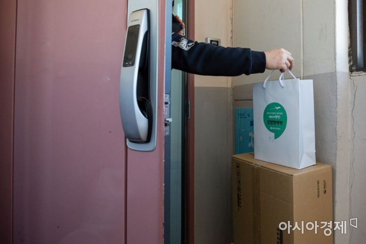 서울 양천구 한 아파트에서 재택치료에 들어간 확진자가 양천구 코로나19재택치료 전담팀이 전달한 '재택치료키트'를 수령하고 있다./강진형 기자aymsdream@