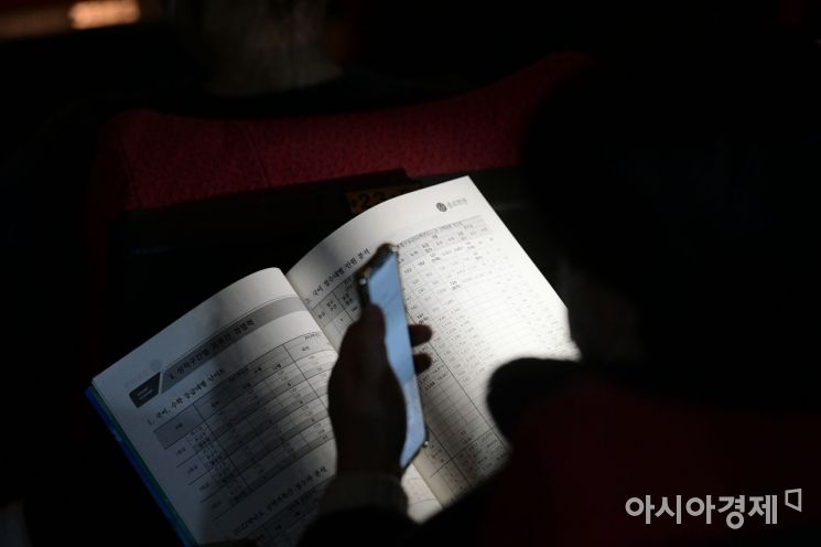 12일 서울 종로구 성균관대학교 600주년 기념관에서 열린 종로학원 2022 대입 정시 합격점수 예측 발표 전략 설명회를 찾은 학부모들과 수험생들이 진지한 표정으로 자료를 보고 있다./윤동주 기자 doso7@