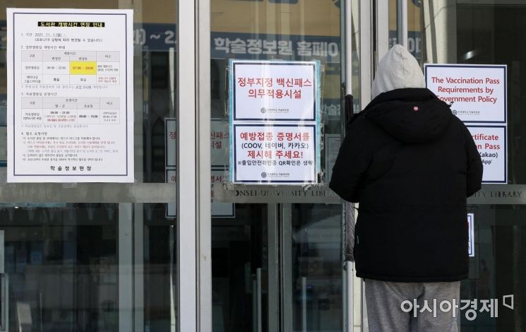 방역패스 의무화가 시작된 13일 서울 서대문구 연세대학교 중앙도서관 입구에 방역패스 확인 안내문이 붙어 있다. 이날부터 식당·카페 등에서 방역패스 확인을 하지 않으면 이용자, 운영자 모두에게 과태료가 부과된다./김현민 기자 kimhyun81@