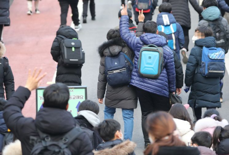 14일 서울 시내 한 초등학교에서 한 학부모가 등교하는 자녀에게 손을 흔들고 있다. (사진출처=연합뉴스)