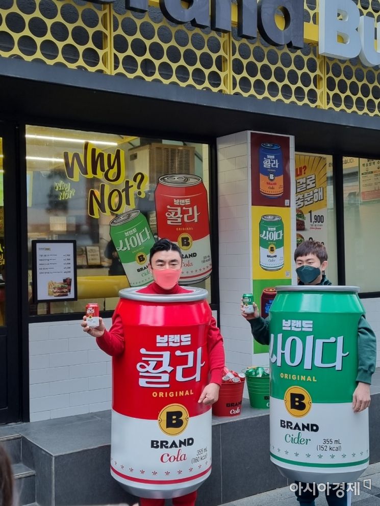 14일 오전 서울 중구 노브랜드 버거 서울시청점 앞에서 송현석 신세계푸드 대표(왼쪽)와 이대희 수원호매실점 가맹점주가 각각 콜라, 사이다 의상을 입고 '브랜드 콜라', '브랜드 사이다'를 홍보하고 있다. 사진=아시아경제 문혜원