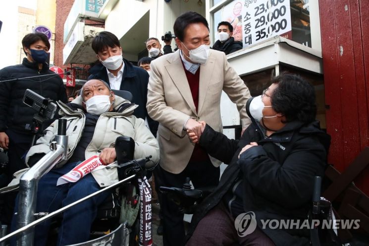 윤석열 국민의힘 대선 후보가 지난 8일 서울 종로구 대학로에서 전국장애인단체차별철폐연대 관계자와 대화하고 있다./사진=연합뉴스