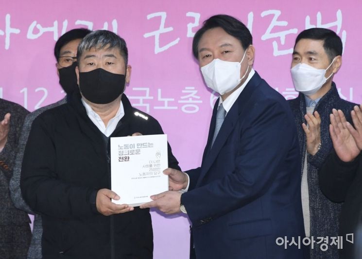 윤석열 국민의힘 대선 후보가 15일 서울 여의도 한국노총에서 열린 노동계와의 간담회에 참석, 간담회 시작에 앞서 김동명 위원장에게 노동현장의 요구를 담은 정책제안서를 받고 있다./윤동주 기자 doso7@