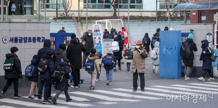 정부가 사회적 거리두기를 다시 강화하기로 결정함에 따라 오는 20일부터 수도권 모든 학교와 비수도권 과대학교, 과밀학급이 전면 등교를 중단하기로 발표한 17일 서울 한 초등학교 인근에서 학생들이 등교하고 있다./강진형 기자aymsdream@