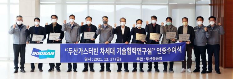 17일 두산중공업 창원 본사에서 열린 '두산가스터빈 차세대 기술협력 연구실' 인증 수여식에서 박홍욱 두산중공업 파워서비스BG장(왼쪽에서 여섯 번째)과 손정락 산업부 R&D 전략기획단 에너지산업 MD(왼쪽에서 일곱 번째)를 비롯해 선정된 대학 연구실 교수들이 기념 촬영을 하고 있다.[사진제공=두산중공업]