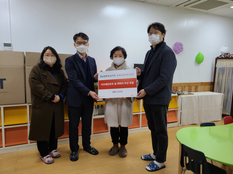 경남정보대 학교 기업 슈키트와 동서대 학교 기업 애니모션이 동성럭키유치원에 부츠와 우산을 기부하고 기념사진을 찍고 있다.