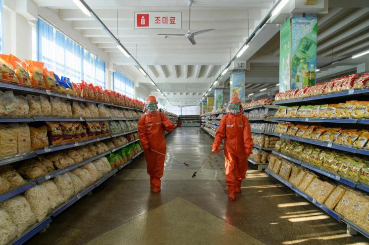 북한 평양의 역전백화점 직원들이 코로나19 예방 조치의 일환으로 매장에 소독제를 살포하고 있다. [이미지출처=연합뉴스]