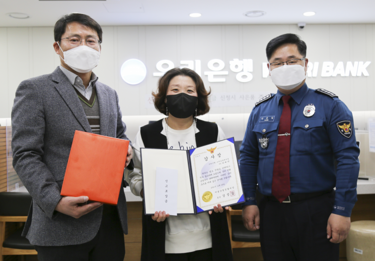 허혜란 우리은행 고덕금융센터 차장(가운데)에게 감사장과 포상금을 지급하고 있다. [사진제공=서울 강동경찰서]