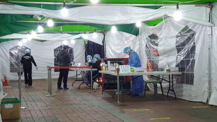 12월 24일 오후 7시께 창원종합버스터미널 앞 코로나19 선별진료소. 의료진은 전기 난로를 사이에 두고 추위를 이겨내고 있었다. /이세령 기자 ryeong@