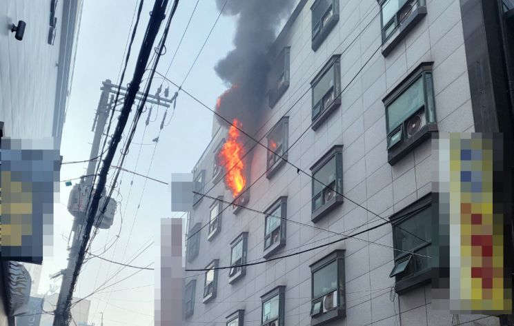 26일 오전 부산 부산진구 한 모텔 창문 밖으로 불길과 연기가 솟구치고 있다. [이미지출처=연합뉴스]