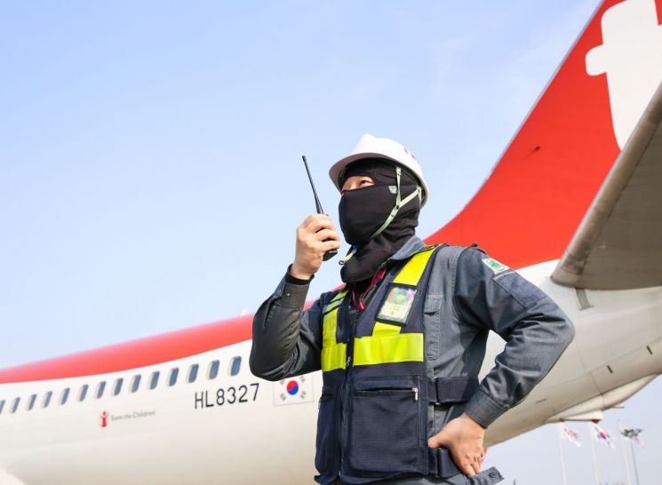 티웨이항공 정비사가 김포공항 주기장에서 새로 지급된 방한용 멀티 두건을 착용하고 항공기 정비 및 점검 업무를 진행하고 있다.