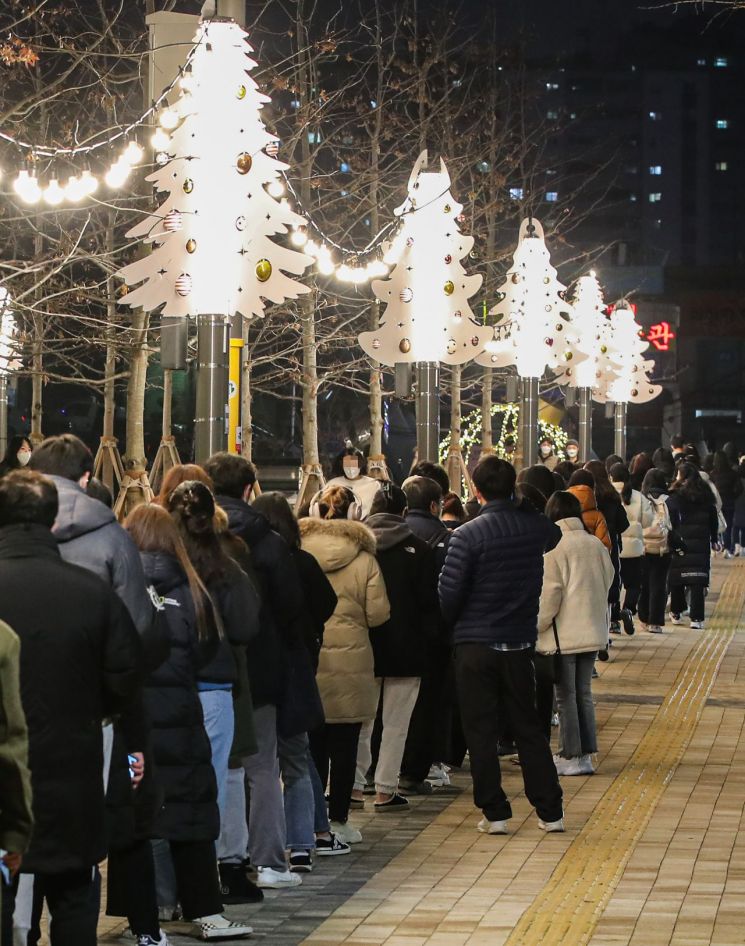 신종 코로나바이러스 감염증(코로나19) 신규 확진이 연일 7천 명대를 기록하는 등 방역 한계 상황에 다다르자 정부가 다시 사회적 거리두기 단계 강화를 발표한 16일 오후 서울 서대문구 신촌역 광장에 마련된 선별진료소를 찾은 시민들이 성탄과 연말을 상징하는 트리 조명 아래 코로나19 검사를 받기 위해 줄지어 서 있다. [이미지출처=연합뉴스]
