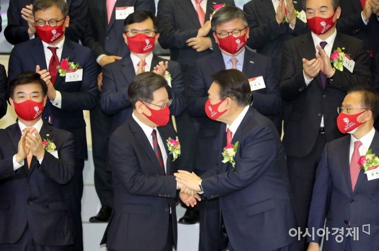 2022년 증권·파생상품시장 개장식이 3일 서울 여의도 한국거래소 서울사옥에서 열렸다. 행사에 참석한 이재명 더불어민주당 대선후보와 윤석열 국민의힘 대선후보가 악수를 나누고 있다./국회사진기자단