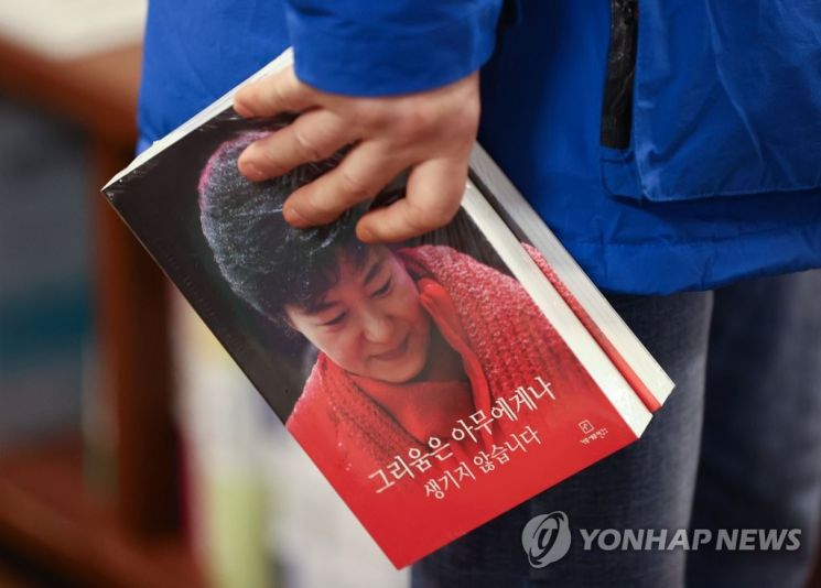한 시민이 박근혜 전 대통령의 자서전 '그리움은 아무에게나 생기지 않습니다'를 들고 있다./사진=연합뉴스