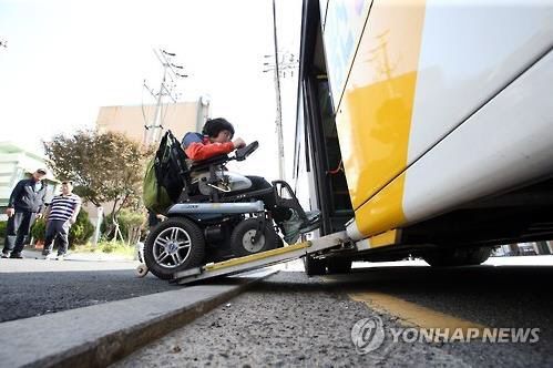 저상버스의 리프트를 이용하는 모습. 저상버스는 장애인의 이동권 확보에 매우 중요한 대중교통 수단이다. / 사진=연합뉴스