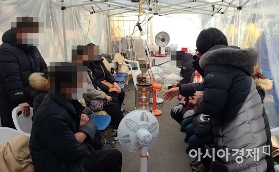 지난 11일 오후 신축 중인 광주 서구 화정아이파크 1개 동 상층부 외벽이 무너져 작업자 6명 연락이 두절된 가운데 가족들이 임시 천막에서 구조 소식을 기다리고 있다.