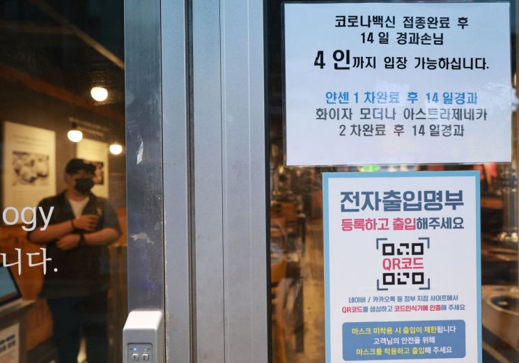 14일 오후 저녁 장사를 앞둔 서울 종로구의 한 식당 입구에 방역패스(백신접종증명·음성확인제) 관련 안내문이 부착돼 있다. [이미지출처=연합뉴스]