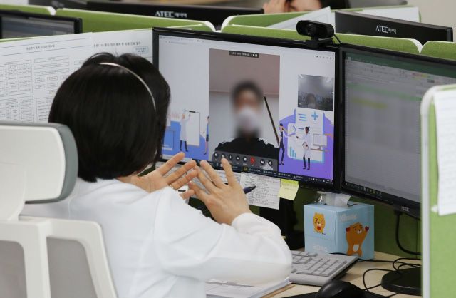 지난 19일 경기도 성남시의료원 재택치료 상황실에서 관계자가 재택치료를 하고 있는 환자의 증세 등을 화상전화를 이용해 체크하고 있다./사진공동취재단