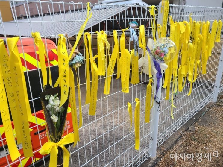 광주광역시 서구 화정아이파크 사고 현장 인근에 설치된 철조망 울타리에 '무사 귀환'을 바라는 노란 리본이 걸려 있다.