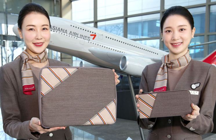 아시아나항공 승무원들이 회수한 유니폼을 이용해 제작한 업사이클링 제품인 테블릿파우치를 소개하고 있다.