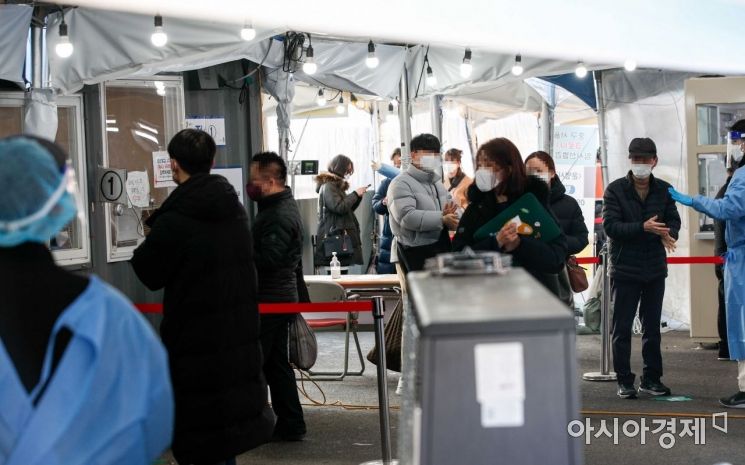 코로나19 신규 확진자가 7513명 발생한 24일 서울 마포구 서강대역 광장에 마련된 임시선별검사소를 찾은 시민들이 검사를 받기 위해 줄을 서고 있다./강진형 기자aymsdream@