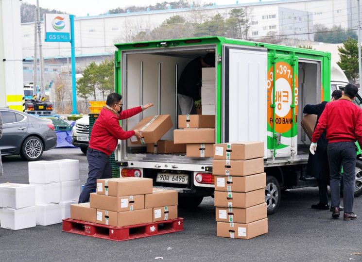 제너시스BBQ 본사 직원이 25일 푸드뱅크 트럭에 기부할 제품을 상차하고 있다.