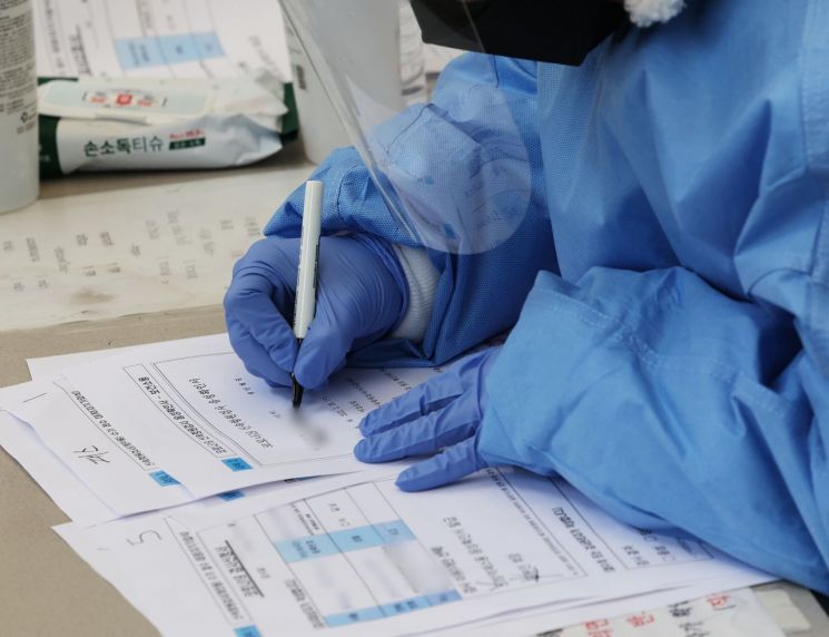 오미크론 방역체계가 시작된 경기도 안성시보건소 선별검사소에서 26일 오전 관계자가 신속항원검사 음성확인서를 작성하고 있다. [이미지출처=연합뉴스]