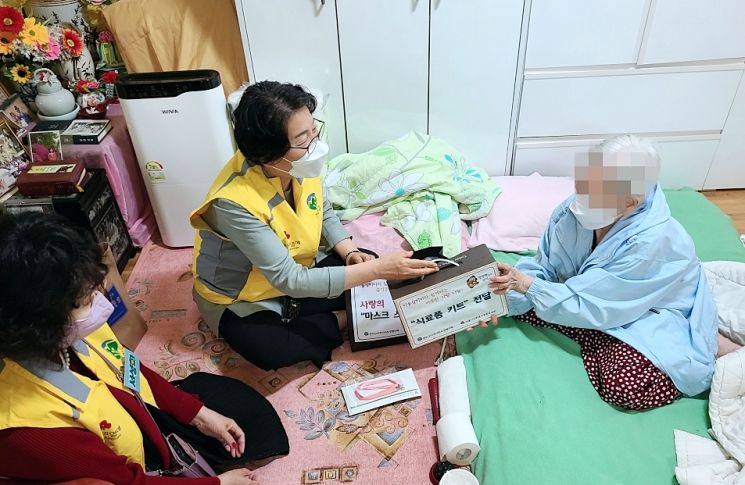 독거어르신에게 식료품·방역 물품를 키트 전달하는 모습