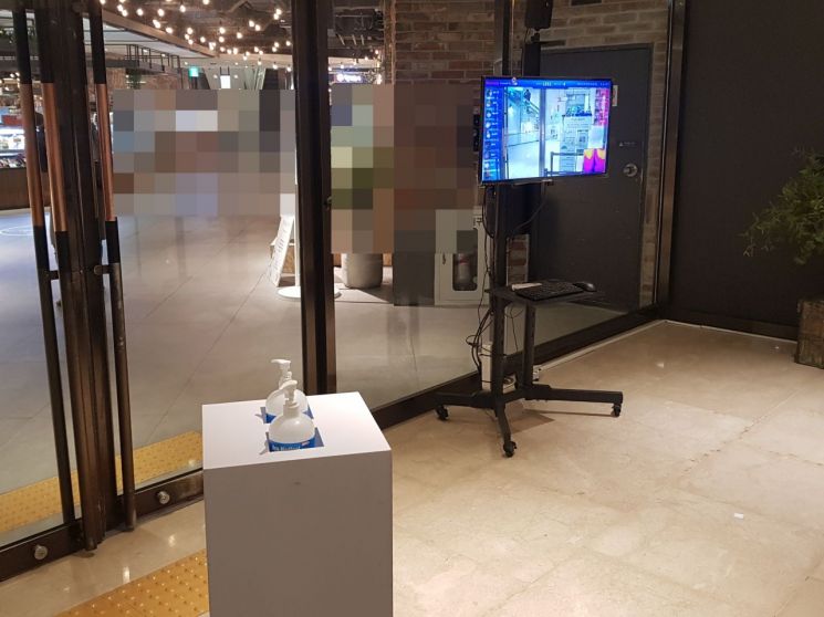 19일 서울 한 백화점 입구에 QR체크인 기계 없이 열화상 카메라와 손소독제만 놓여 있다.