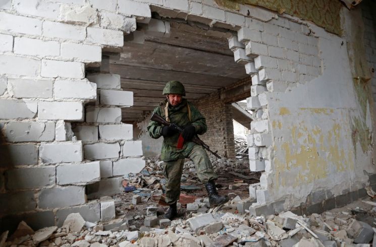 17일(현지시간) 우크라이나 돈바스 지역 친러반군 조직인 루간스크 인민공화국 지배지역인 몰로디즈네에서 우크라이나 정부군의 폭격을 받은 학교건물을 병사들이 점검하고 있다. 친러반군들은 우크라이나 정부군이 선제공격을 했다고 주장하고 있다. 몰로디즈네(우크라이나)= 로이터·연합뉴스