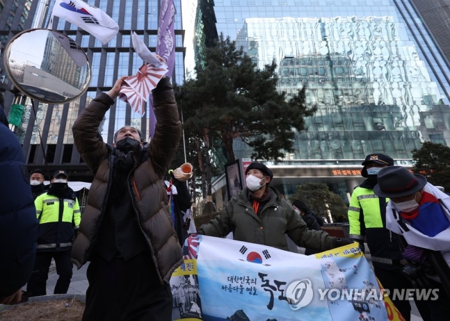 일본정부가 '다케시마의 날' 행사를 개최한 22일 종로구 주한일본대사관 옛터 앞에서 한 시민단체 회원이 욱일기가 그려진 종이를 찢으며 항의하고 있다. [이미지출처=연합뉴스]