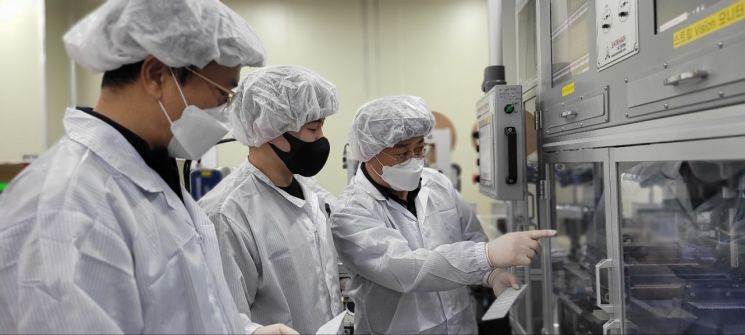 충남 천안에 위치한 자가진단키트 생산업체 '젠바디'에서 삼성전자 스마트공장 전문가와 젠바디 직원(가운데)이 자가진단키트 조립 라인을 점검하고 있다. (사진=삼성전자 제공)