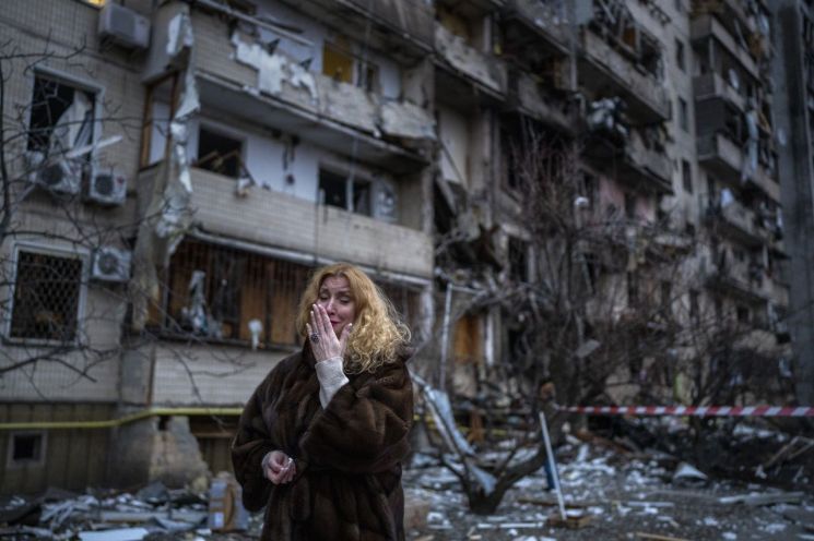 로켓 공격을 받아 벽면이 너덜너덜한 잔해물 더미로 변한 우크라이나 수도 키예프의 아파트 건물 앞에서 25일(현지시간) 이곳에 살던 한 여성이 절규하고 있다. [이미지출처=AP연합뉴스]