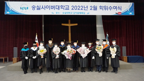 [조성기 이사장, 한헌수 총장 및 학과장들과 졸업생들(수장자들)이 포즈를 취하고 있다.]