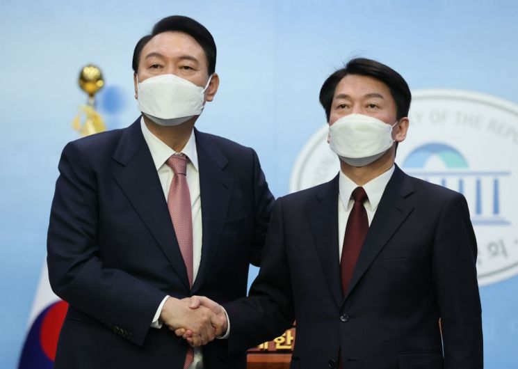 윤석열 국민의힘 대선 후보와 안철수 국민의당 대선 후보가 3일 오전 국회 소통관에서 단일화 기자회견을 마치며 악수하고 있다. [이미지출처=연합뉴스]