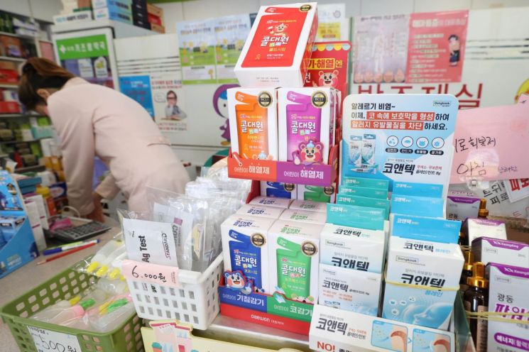 코로나19 대규모 유행으로 어린이 확진자 증가세를 보이는 6일 서울의 한 약국에서 관계자가 소아용 해열제와 감기약 등 소아재택 치료 키트를 진열하고 있다. [이미지출처=연합뉴스]