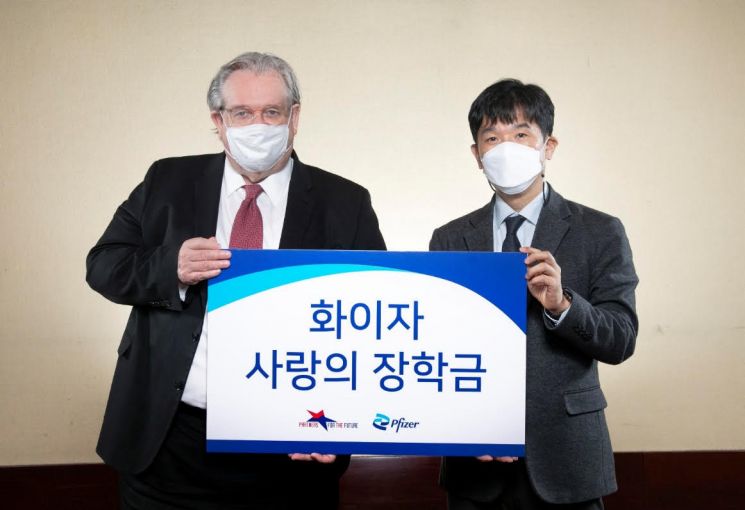 오동욱 한국화이자제약 대표이사 사장(사진 오른쪽)이 제프리 존스 미래의동반자재단 이사장에게 '화이자 사랑의 장학금'을 전달하고 있다.