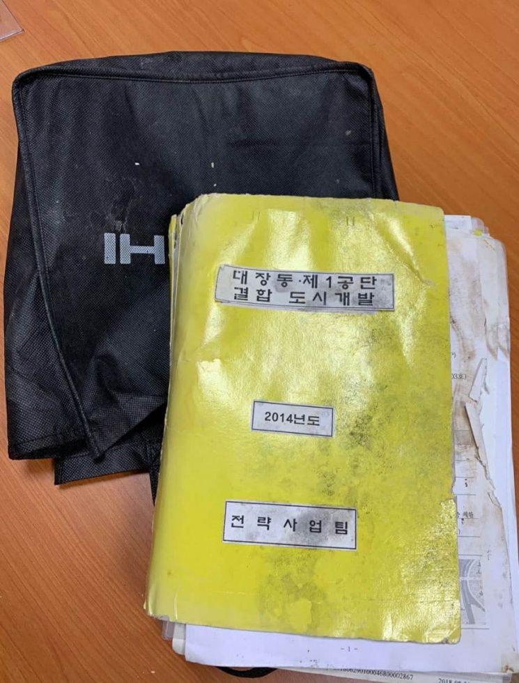 지난달 25일 원희룡 국민의힘 선대본부 정책본부장이 안양∼성남 간 제2경인고속도로 분당 출구 인근 배수구에 버려져 있는 '대장동 문건 보따리'를 입수했다고 밝히며 제시한 문건과 가방. [이미지출처=연합뉴스]