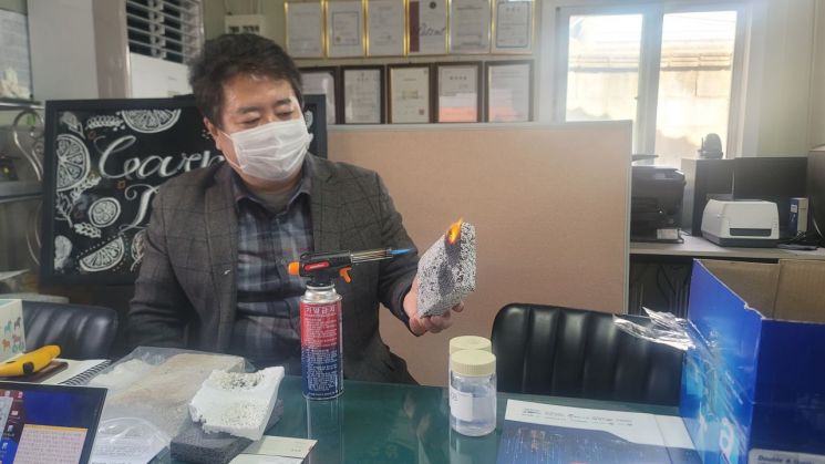한승우 한미르 대표가 자사 특허 물질인 '실마겔'을 적용한 단열재에 열을 가하고 있다.