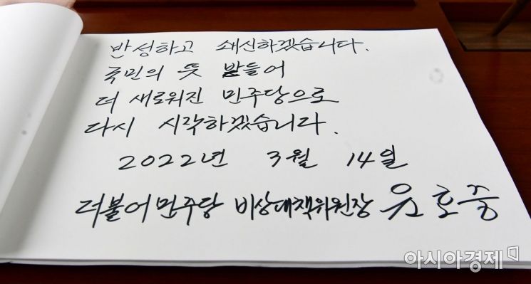 윤호중 더불어민주당 비상대책위원장 겸 원내대표가 14일 서울 동작구 서울현충원에서 참배를 마친 후 방명록을 남기고 있다./국회사진기자단