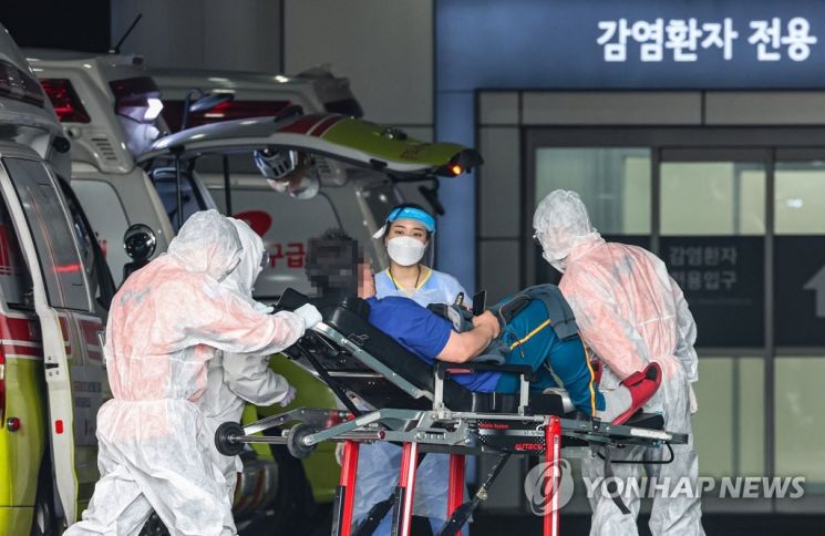 지난 17일 서울 중랑구 서울의료원에서 119 구급대원과 의료진이 병원에 도착한 환자를 감염병 전문 병동으로 이송하고 있다. / 사진=연합뉴스
