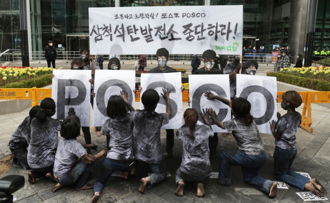 녹색연합 활동가들이 검은색 가루를 온몸에 묻히고 포스코의 석탄발전소 건설 사업을 규탄하는 퍼포먼스를 진행 중이다. 연합뉴스