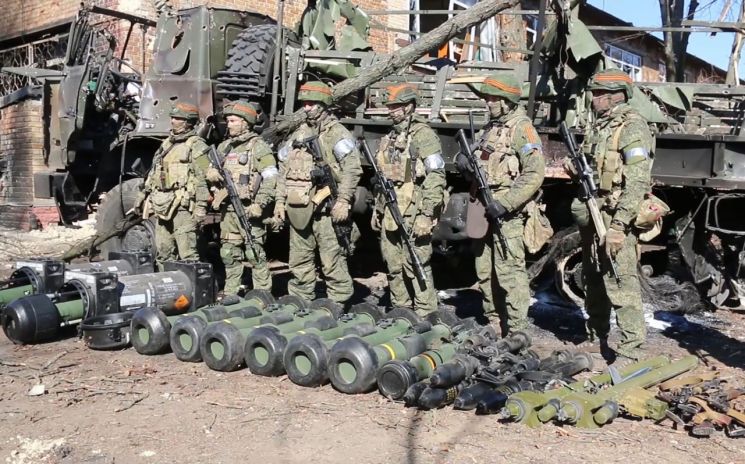 15일(현지 시각) 우크라이나 수도 키이우(키예프) 지역에서 러시아 군인들이 노획한 서방 제공 무기들을 전시해 놓고 그 뒤에 도열해 있다. [사진=연합뉴스=
